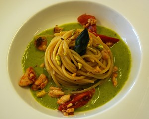 Spaghetti con sgombro, pomodorini e granella di pistacchi su crema di asparagi